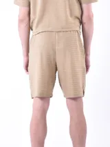 Bermuda de hombre color gris oscuro con textura de líneas horizontales.