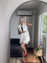 Conjunto color naranja compuesto por un chaleco sin mangas con solapas y un short de tiro alto con elástico en la parte trasera.