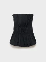 Top strapless de algodón color negro, con cuerpo fruncido y bajo abullonado tipo peplum. Cuenta con cierre de cremallera en la parte posterior y forro interior.