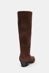 Bota de caña alta confeccionada en serraje, con diseño estilo cowboy, acabado en punta y tacón kitten en bloque.