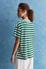 Remera de corte holgado con diseño a rayas horizontales en color verde y blanco, cuello redondo y mangas cortas con vuelta.