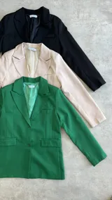 Blazer verde esmeralda de corte clásico con solapas y cierre con botones.