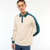Remera polo de manga larga con diseño bicolor, combinando cuerpo en color beige con cuello, tapeta de botones y mangas en color verde oscuro.