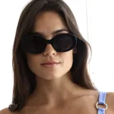 Lentes de sol con armazón ovalado de estilo retro, fabricados en acetato negro con cristales oscuros y protección UV400.