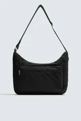 Bolso de hombro tipo hobo o media luna, confeccionado en tejido técnico negro. Presenta un bolsillo frontal con cierre y una correa ajustable para llevar al hombro.
