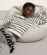 Blusa corta de tejido de punto a rayas horizontales color verde y blanco, de mangas largas y cuello redondo.