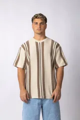 Remera de tejido de punto con diseño de rayas verticales en tonos beige y marrón, de manga corta y cuello redondo.