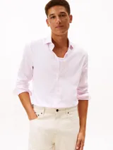 Camisa de manga larga color rosado pastel, confeccionada en algodón con textura dobby y sutil elasticidad. Presenta cuello camisero clásico, cierre frontal con botones y puños ajustables con botones.
