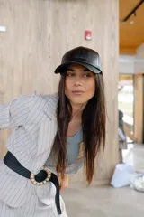 Gorra tipo béisbol de cuero sintético negro, con diseño minimalista y ajuste posterior metálico.