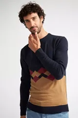 Sweater de punto con diseño color block, combinando azul marino en la parte superior, un patrón geométrico en tonos bordó y azul en el centro, y color camel en la parte inferior. Presenta cuello redondo y mangas largas.