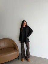 Conjunto compuesto por un buzo de punto acanalado en color beige con cuello redondo y mangas largas holgadas, y un pantalón tipo oxford de tiro alto con estampado animal print de leopardo.