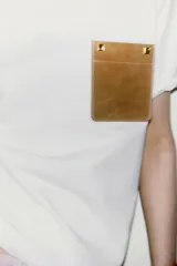 Camiseta blanca de algodón, corte regular, cuello redondo y manga corta, con bolsillo cuadrado de tejido efecto piel color camel en el pecho.