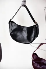 Cartera negra tipo baguette de cuero sintético con logo de la marca estampado en el frente.