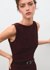 Mono largo de corte recto y diseño sin mangas con cuello barco. Confeccionado en tejido jaspeado, cuenta con cierre de cremallera en la parte posterior y cinturón fino ajustable con hebilla metálica.