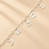 Pulsera de cadena de eslabones de plata 925 con múltiples dijes colgantes de formas variadas, incluyendo una luna, una mariposa, una manzana, una flor y un ángel.