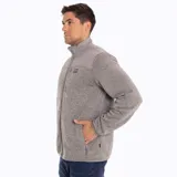 Campera polar gris jaspeado con cuello alto y cierre frontal completo. Tiene paneles lisos en contraste en la parte superior del pecho y la espalda.