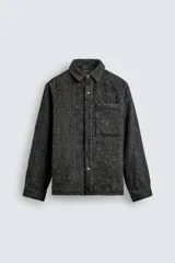 Sobrecamisa de corte relajado confeccionada en tejido con textura efecto pelo, color gris oscuro jaspeado. Presenta cuello solapa, cierre frontal con botones, manga larga con puños abotonados y un bolsillo de plastrón en el pecho.