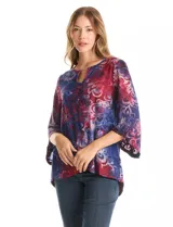 Blusa Ruby Rd. de corte holgado con diseño texturizado y estampado floral en tonos azul y bordó. Presenta cuello redondo con escote tipo keyhole y detalle metálico, mangas tres cuartos amplias y dobladillo asimétrico.