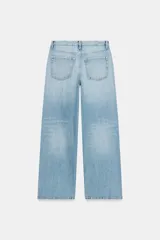 Jeans de tiro medio con diseño de cinco bolsillos y pierna ancha. Presenta un corte recto y holgado con bajo acabado sin costuras y cierre frontal con cremallera y botón metálico.