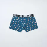 Pack de tres boxers de corte ajustado con cintura elástica ancha con la palabra Ultimate estampada. Incluye un modelo con estampado de hojas tropicales en tonos oscuros, un modelo liso en color tostado y un modelo con estampado de frutas en tonos azulados.