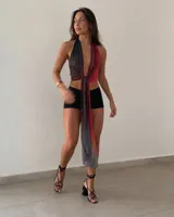Top halter con diseño bicolor en negro y rojo, con escote pronunciado en V y un lazo largo cruzado al frente que cae hacia abajo.