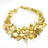 Collar corto dorado con cuentas y apliques de flores y hojas.