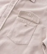 Camisa de hombre de corte regular confeccionada en terciopelo de algodón, con cuello clásico, cierre frontal de botones y dos bolsillos con solapa en el pecho.