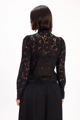 Blusa blanca de encaje con cuello mao, manga larga y cierre frontal con presillas y botones de tela.