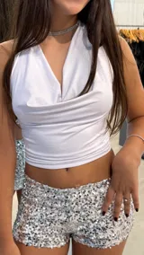 Top blanco de escote halter con diseño drapeado en el frente y corte ajustado al cuerpo.