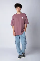 Remera negra de corte oversize confeccionada en algodón pesado, con estampa pequeña de Mickey Mouse en el pecho y diseño gráfico en la espalda.