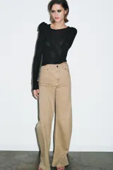 Jeans de tiro alto con corte wide leg y largo completo. Presenta diseño de cinco bolsillos, cintura con trabillas y cierre frontal con cremallera y botón.