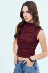Top Bonnie negro sin mangas, con cuello alto y diseño ajustado con fruncidos laterales.