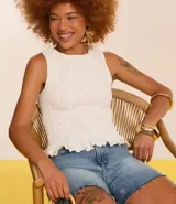 Musculosa blanca con cuello redondo, diseño con lastex y volado en el bajo.