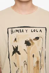 Camiseta de algodón orgánico color negro con efecto gastado, corte oversize y manga corta ancha. Presenta un estampado artístico enmarcado con el texto "BIMBA Y LOLA" en la parte superior e inferior.