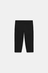 Pantalón capri de tiro medio confeccionado en tejido elástico, con cierre lateral mediante cremallera oculta.