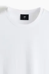 Remera lisa de corte ajustado en punto suave de algodón pima, con cuello redondo ribeteado acanalado fino y bajo recto.
