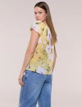 Blusa de gasa semitransparente color azul marino con estampado floral en tonos celestes y lilas, cuello redondo elastizado con lazo central y mangas cortas con doble volado.