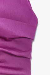 Top color fucsia de escote recto y tirantes finos, con detalle de pliegues y espalda descubierta. Cierre con lazadas en la espalda.