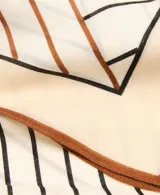 Fular cuadrado de lana con estampado geométrico en tonos beige, marrón y negro, con bordes definidos.