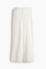 Pantalón de punto color blanco, de corte amplio y relajado, con cintura elástica y cordón ajustable.