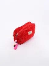 Necessaire de textura tipo felpa o chenille en color celeste, con cierre perimetral y etiqueta frontal de la marca Common Wear. Incluye un detalle de cadena plástica multicolor con una placa rosa colgante en el lateral.