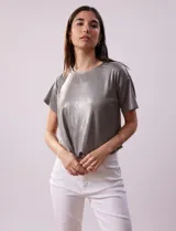 Blusa gris metalizada de tejido lurex, marca June & Hudson, con cuello redondo y ruedo con nudo en la espalda.