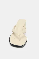 Sandalia color crema con doble tira delantera y tacón ancho.