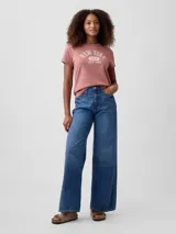 Remera de manga corta con cuello redondo, color rosado, con estampa frontal con texto New York Gap Est. 1969 en color blanco.