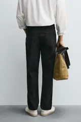 Pantalón de corte recto confeccionado en tejido de algodón con elasticidad. Presenta diseño de cinco bolsillos, cierre frontal con cremallera y botón.