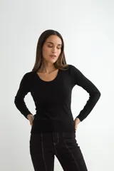 Sweater de punto fino en color negro, con cuello redondo y mangas largas, de corte ajustado al cuerpo.