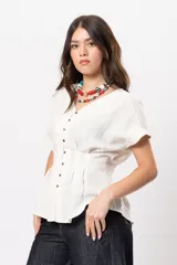 Blusa beige melange con escote en V, manga corta caída, botones metálicos frontales y pinzas que marcan la cintura.