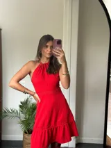 Vestido corto color celeste con espalda descubierta, tirantes finos y detalles de encaje en la cintura y el ruedo, con falda con volado.