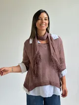 Sweater de punto color marrón chocolate con cuello redondo, mangas tres cuartos y diseño asimétrico. Incluye un pañuelo a juego con detalles de puntilla en los bordes.