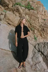 Jeans negro de tiro medio con corte balloon fit, diseño de cinco bolsillos y bajo acabado en puño con abertura y botón.